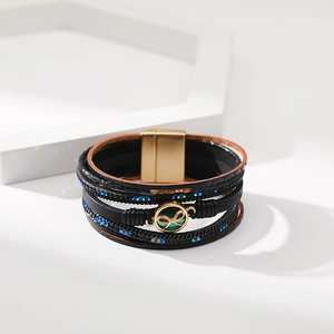 Dettaglio del bracciale in pelle multistrato con accenti di cristallo e chiusura magnetica