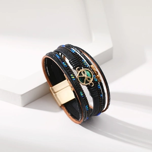 Dettaglio di un bracciale multistrato in pelle con perline blu e chiusura magnetica dorata