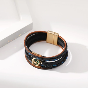 Dettaglio del bracciale in pelle multistrato con strass blu e chiusura magnetica