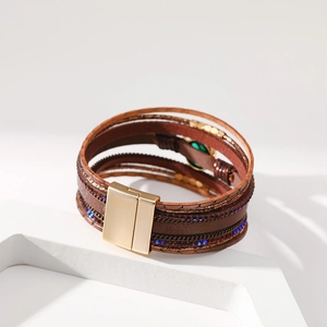 Dettaglio del bracciale multistrato in pelle boho con gemme e chiusura magnetica dorata