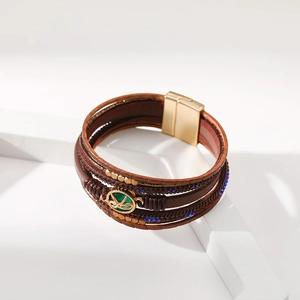 Dettaglio del bracciale bohémien multistrato in pelle con ciondolo gemma e chiusura magnetica
