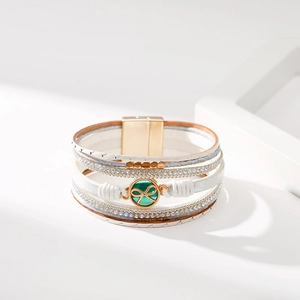 Dettaglio del bracciale bohémien multistrato in pelle bianca con strass e fiocco