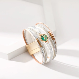 Dettaglio del bracciale bohémien multistrato con cinturini in pelle bianca e chiusura