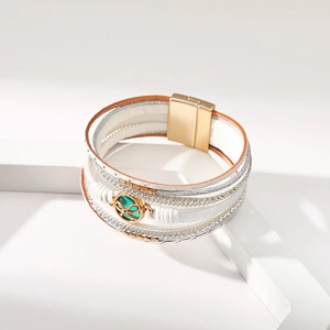 Dettaglio del bracciale bohémien multistrato in pelle con strass e chiusura magnetica