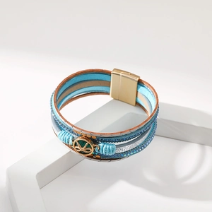 Dettaglio di un braccialetto bohémien in pelle blu multistrato con paillettes e chiusura magnetica