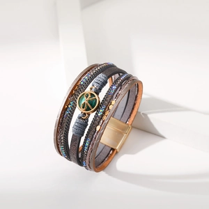 Dettaglio del bracciale multistrato in pelle boho con gemma verde e chiusura magnetica