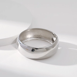 Polished silver drum-style bangle featuring a smooth mirror surface and hinge closure