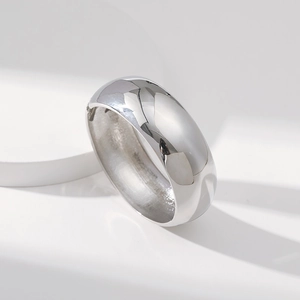 Close-up of polished silver wide dome ring showing reflective surface on geometric pedestal