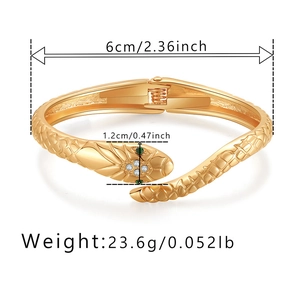 Dettaglio del bracciale a serpente dorato con occhi di gemma verde e zirconi