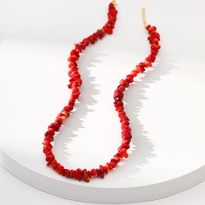 Elegante onregelmatige rode natuurstenen halsketting met gouden sluiting op witte display