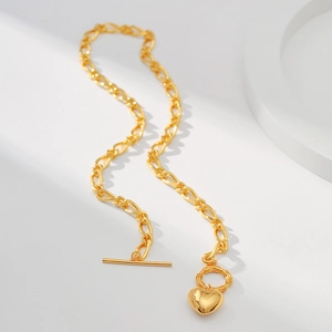 Detailansicht der goldenen Gliederkette mit Herzanhänger und OT-Verschluss auf Weiß
