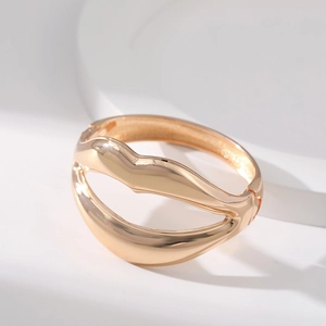 European style golden alloy wave bangle with a unique hollowed-out textured design