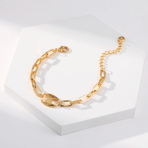 Classic gold-plated metal link bracelet with coffee bean motif on a white display stand