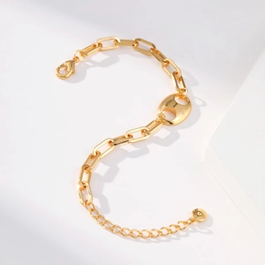 Detail of gold chain bracelet featuring a pig nose clasp and lobster buckle closure