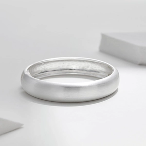 Détail du bracelet en métal brossé argenté doté d'un système de fermeture à charnière
