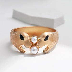Details eines Vintage-Pantherkopfarmbands in Mattgold mit zwei weißen Perlen