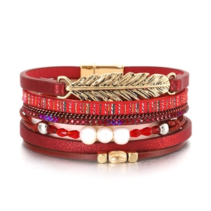 Détail du bracelet bohème rouge perlé avec breloque feuille dorée et fermoir magnétique