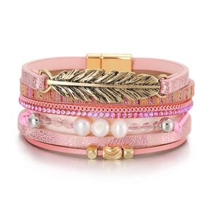 Détail du bracelet bohème multicouche en cuir rose avec breloque feuille et strass