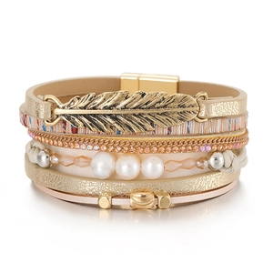 Détail du bracelet multicouche bohème en cuir avec perles et breloque feuille dorée