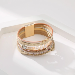 Détail d'un bracelet bohème multicouche avec perles et breloque en forme de feuille