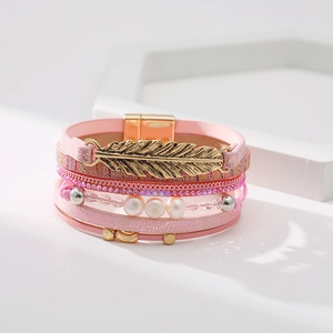 Détail du bracelet bohème rose avec breloque plume dorée et fermoir magnétique