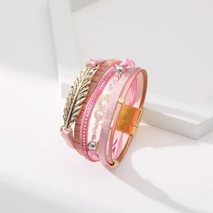 Détail d'un bracelet bohème multicouche rose avec breloque feuille et fermoir magnétique