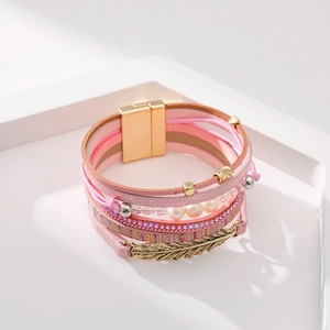 Détail du bracelet multicouche bohème rose avec pendentif plume et fermoir magnétique