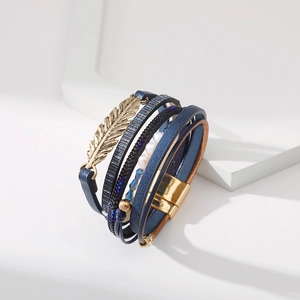 Détail du bracelet multicouche en cuir bleu bohème avec breloque feuille et perles d'or