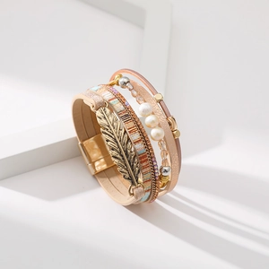Vue détaillée du bracelet multicouche en cuir avec plume dorée et perles de style bohème