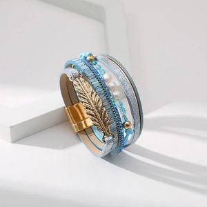 Détail d'un bracelet multicouche bohème avec perles, breloque feuille et fermoir aimanté