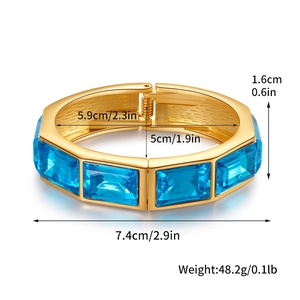 Vista dettagliata di un bracciale dorato a fascia larga con otto gemme blu rettangolari