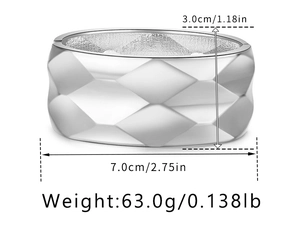 Macro shot of wide silver geometric bangle with diamond pattern texture and dimensions