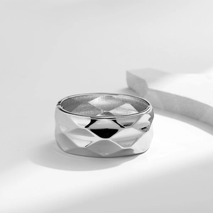 Macro view of wide silver metal ring with a 3D geometric diamond lattice pattern texture
