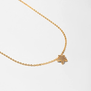 Macro shot of gold starfish necklace pendant with micro-paved sparkling crystals