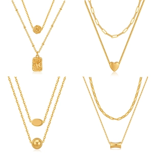 Set of four double-layer gold necklaces featuring heart, rose, and geometric pendants