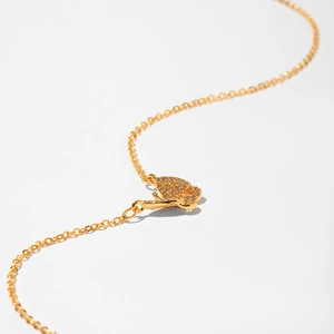 Close-up of golden butterfly pendant necklace with sparkling micro-pave crystals