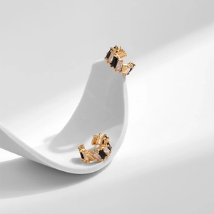 Two-tone C-shaped ear cuffs with black and white zircon stones on a gold base