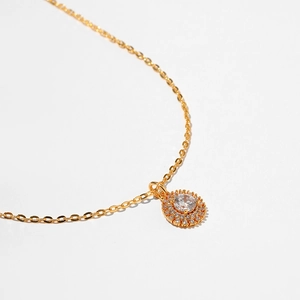 Macro detail of gold starfish pendant with sparkling zircon inlay and refined cross chain