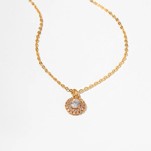 Close-up of golden sunflower pendant with zircon stones and sparkling details