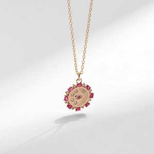 Dettaglio della collana a moneta d'oro con incisione malocchio e gemme rosa