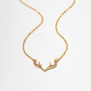 Macro shot of gold reindeer antler pendant with micro-inlaid cubic zirconia on cable chain