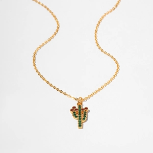 Detail of gold starfish necklace featuring a cactus pendant with red and green zircons