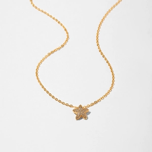 Close-up of gold starfish necklace with zircon stones on a delicate cable chain