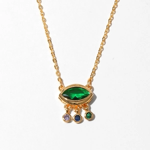 Detail of gold starfish evil eye necklace with green marquise gemstone and colorful drops