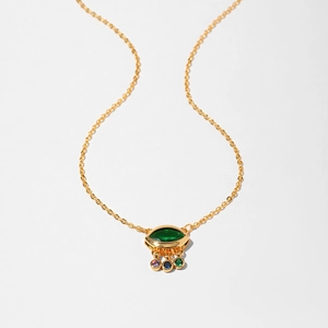 Detailed view of a gold starfish necklace with a green eye-shaped pendant and gemstones