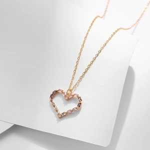 Dettaglio della collana a cuore dorata con zirconi multicolore e catena sottile lucida
