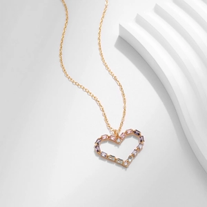 Collana con ciondolo a cuore dorato e zirconi multicolori su supporto bianco