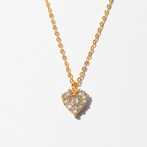 Close-up of gold heart pendant necklace featuring shimmering pave-set cubic zirconia crystals