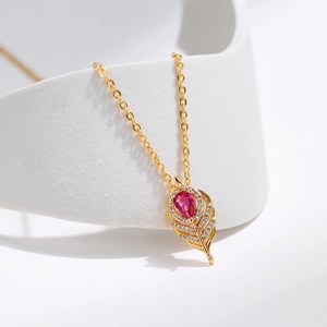 Dettaglio collana in oro con ciondolo in zircone rosso e cristalli bianchi fini