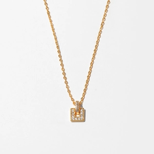 Detail of gold necklace featuring a rectangular pendant micro-set with white zircons